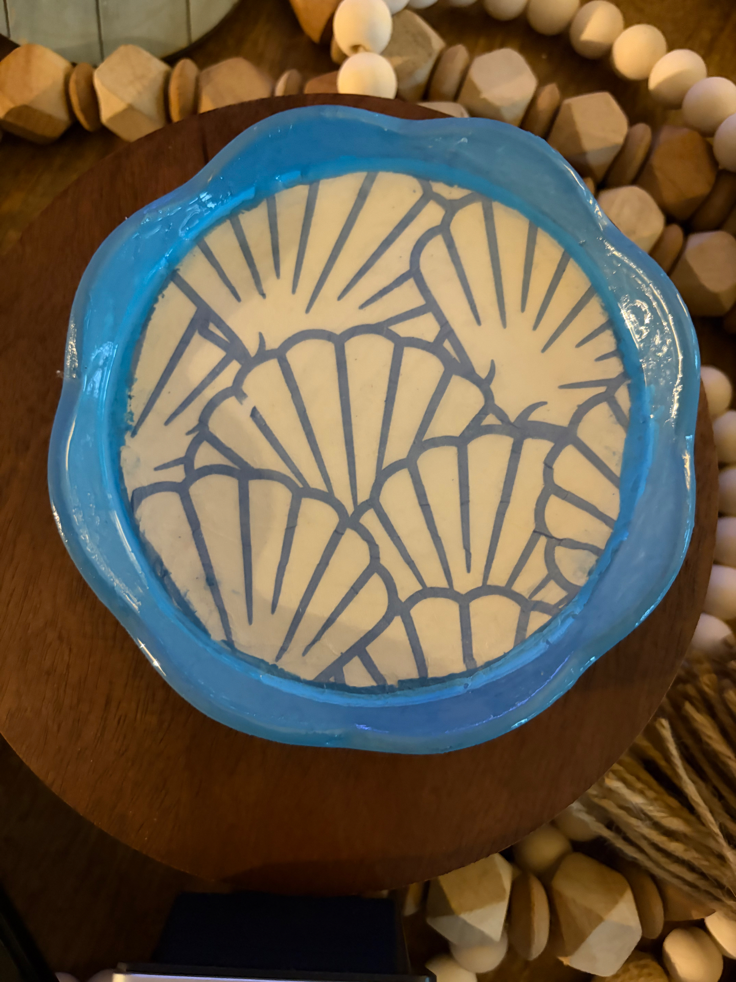 Bright azure-blue clay bowl with scallop shell illustrations decoupaged inside.