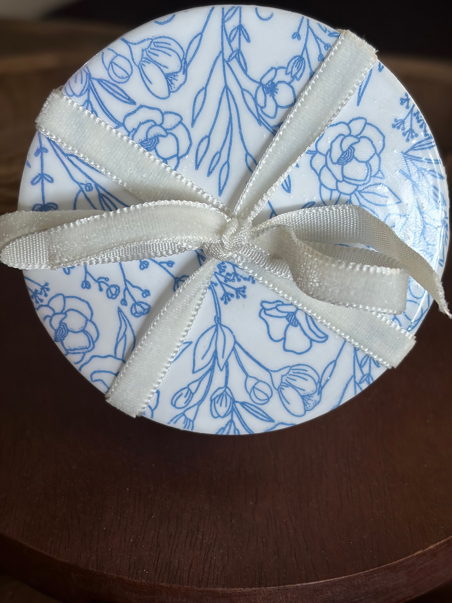 Set of four round coasters with a blue botanical decoupaged design.