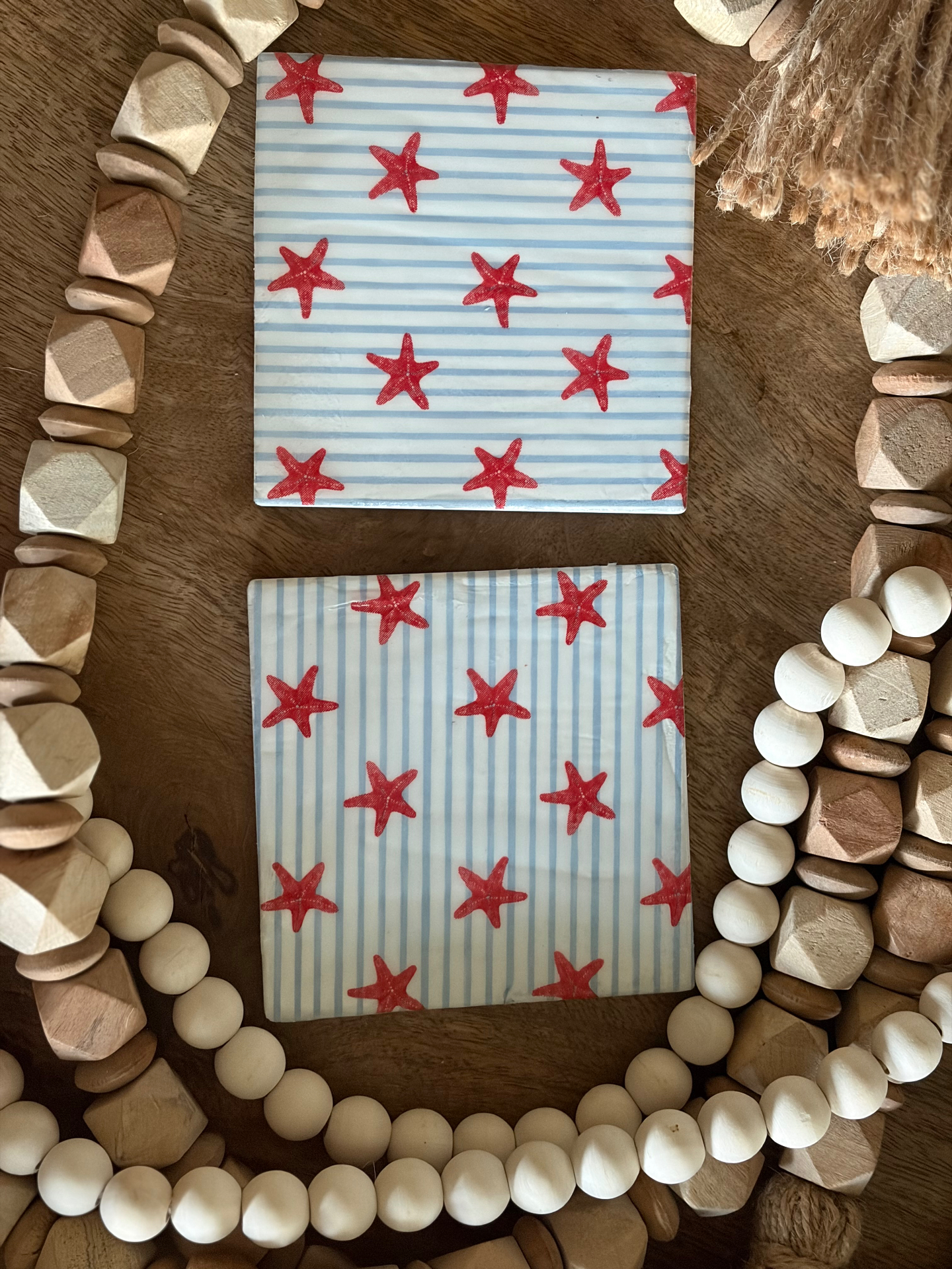 Pair of ceramic tile coasters with starfish and blue stripe patterns.