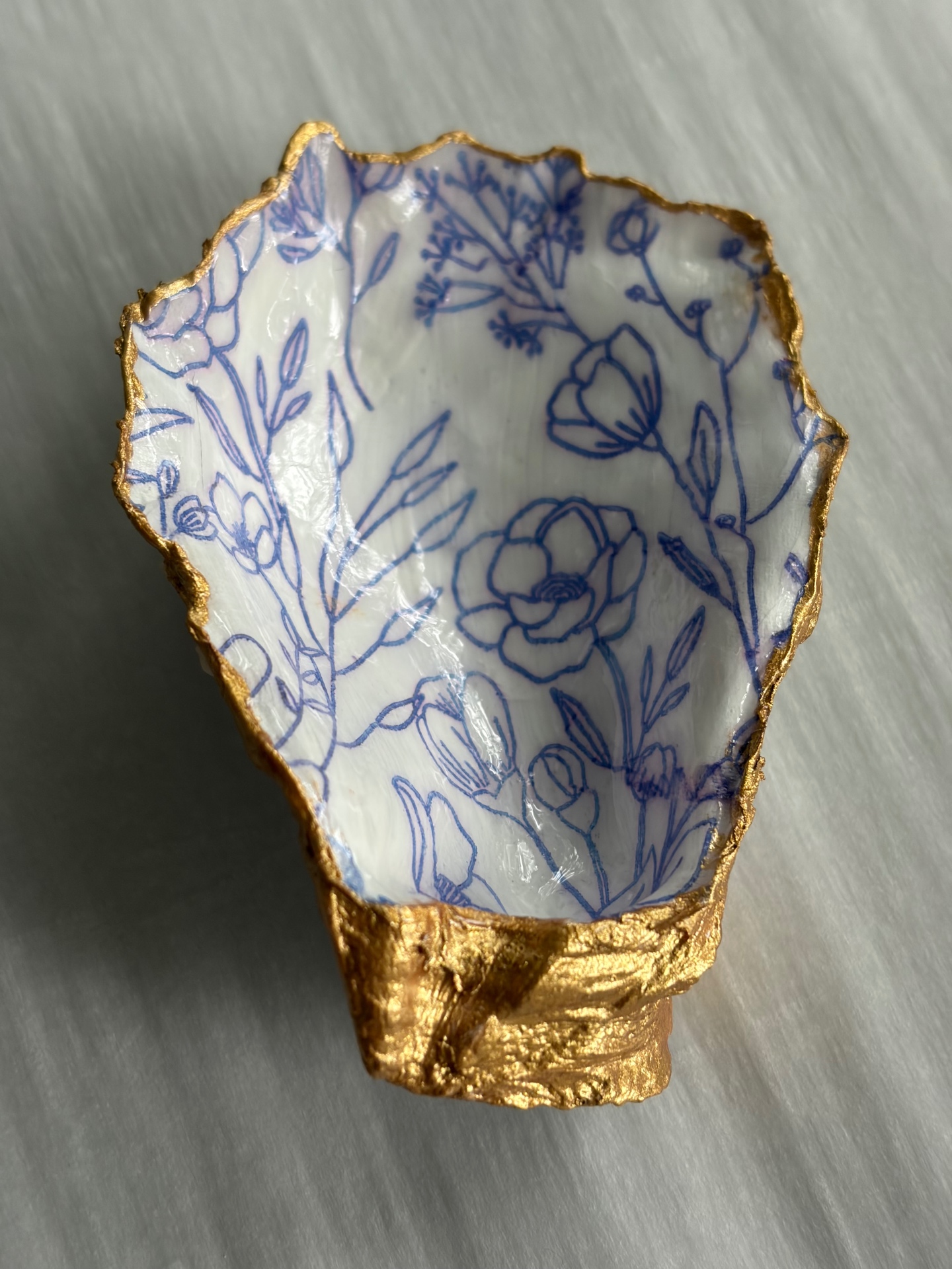 Small scallop-shaped trinket dish painted with delicate floral motifs.